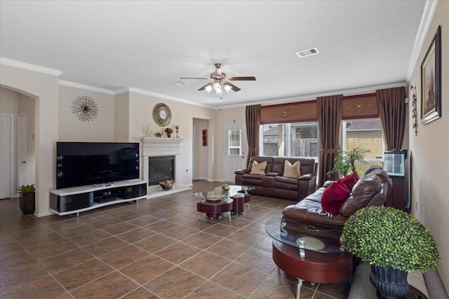 3418 Quarry Place Ln, Katy, TX 77493 - living area with dark tile patterned flooring, crown molding, a ceiling fan, a fireplace with raised hearth, and arched walkways