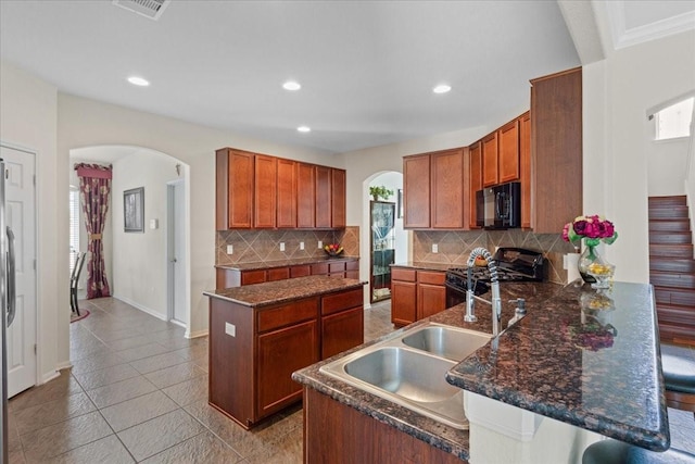 3418 Quarry Place Ln, Katy, TX 77493 - kitchen featuring black appliances, arched walkways, decorative backsplash, a peninsula, and recessed lighting