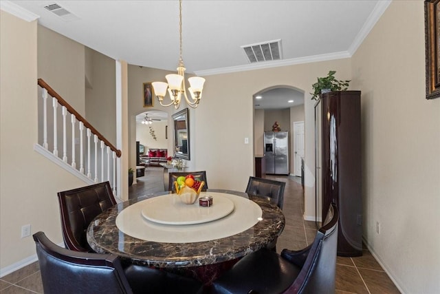 3418 Quarry Place Ln, Katy, TX 77493 - dining room featuring arched walkways, a chandelier, stairway, dark tile patterned floors, and crown molding