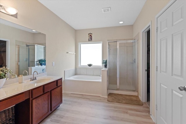 3418 Quarry Place Ln, Katy, TX 77493 - bathroom featuring a walk in closet, vanity, a stall shower, a bath, and wood finished floors