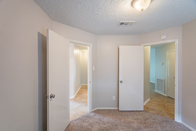 11714 Welshpool Glen Dr, Houston, TX 77066 - unfurnished bedroom featuring tile patterned flooring, carpet, and a textured ceiling