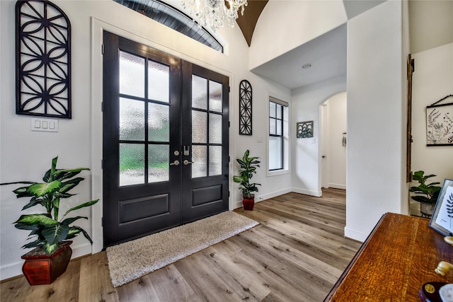 151 Alamo Dr, Huntsville, TX 77340 - foyer entrance with french doors, arched walkways, wood finished floors, healthy amount of natural light, and vaulted ceiling