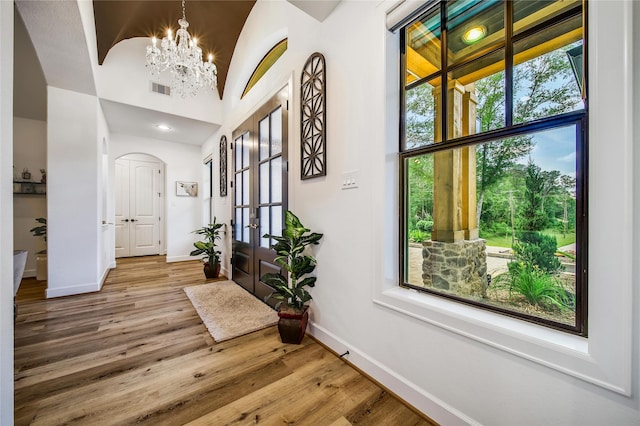 151 Alamo Dr, Huntsville, TX 77340 - foyer with baseboards, a chandelier, arched walkways, wood finished floors, and french doors