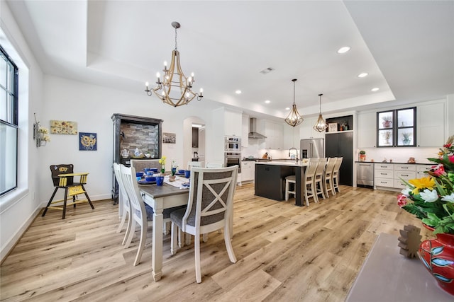 151 Alamo Dr, Huntsville, TX 77340 - dining room with a raised ceiling, a chandelier, light wood finished floors, arched walkways, and recessed lighting