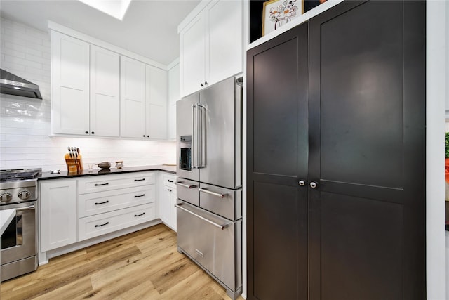 151 Alamo Dr, Huntsville, TX 77340 - kitchen featuring appliances with stainless steel finishes, light wood finished floors, white cabinets, and backsplash