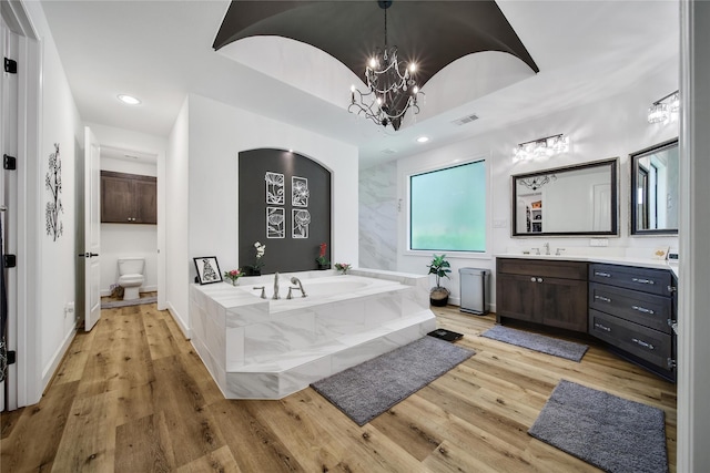 151 Alamo Dr, Huntsville, TX 77340 - full bathroom featuring wood finished floors, a bath, a chandelier, vanity, and recessed lighting