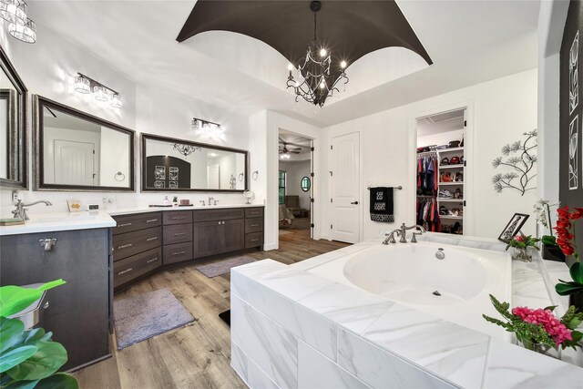 151 Alamo Dr, Huntsville, TX 77340 - full bath with wood finished floors, vanity, a garden tub, a chandelier, and a ceiling fan