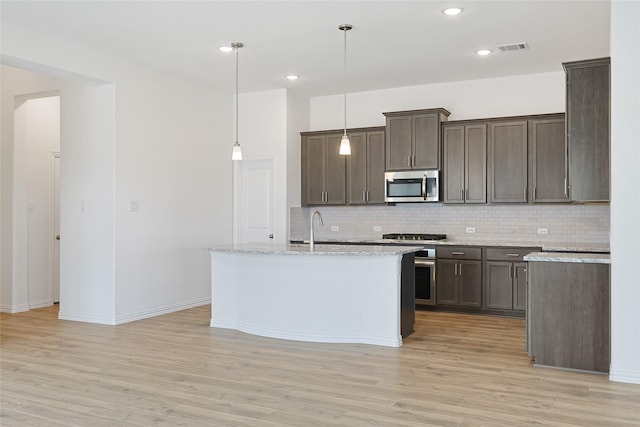 27519 Beachside Arbor Dr, Katy, TX 77493 - kitchen with stainless steel microwave, backsplash, light wood-style flooring, and recessed lighting