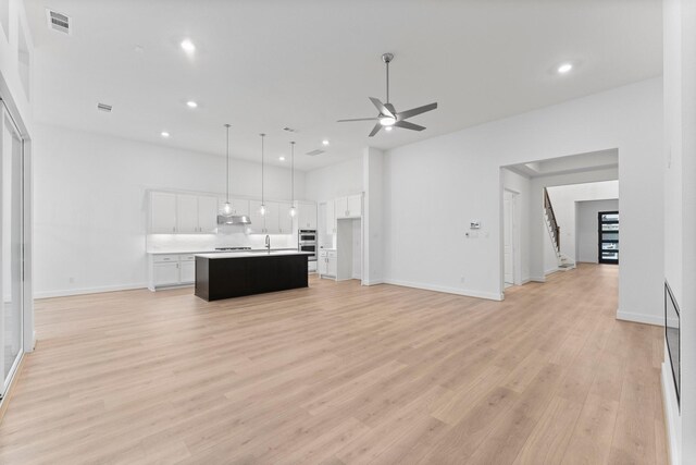 26915 Longwood Ledge Dr, Spring, TX 77389 - unfurnished living room with a ceiling fan, light wood finished floors, recessed lighting, baseboards, and a sink