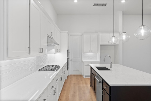 26915 Longwood Ledge Dr, Spring, TX 77389 - kitchen with appliances with stainless steel finishes, a sink, under cabinet range hood, an island with sink, and white cabinets
