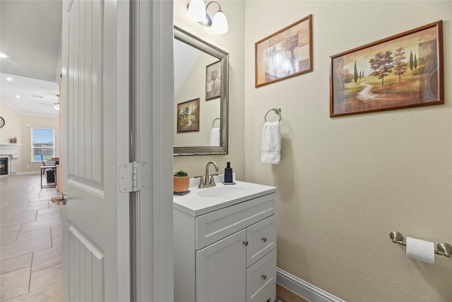 15702 Belmar Heights Dr, Cypress, TX 77429 - bathroom featuring vanity, a ceiling fan, recessed lighting, a warm lit fireplace, and baseboards