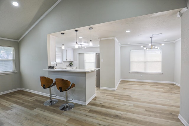 14139 Whispering Palms Dr, Houston, TX 77066 - kitchen featuring a chandelier, lofted ceiling, a sink, a breakfast bar area, and a peninsula
