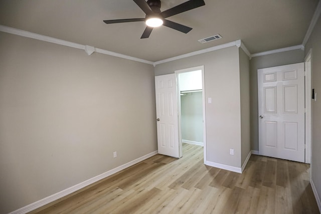 14139 Whispering Palms Dr, Houston, TX 77066 - unfurnished bedroom with light wood-type flooring, crown molding, baseboards, a spacious closet, and ceiling fan