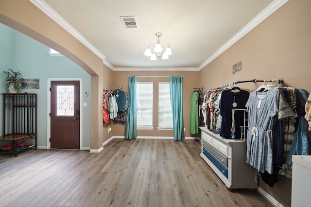28935 Hidden Cove Dr, Magnolia, TX 77354 - entryway with a chandelier, light wood-type flooring, ornamental molding, baseboards, and arched walkways