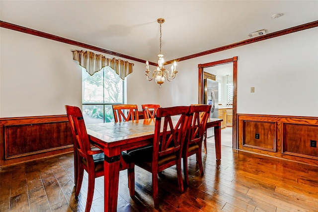 6225 Morton Rd, Katy, TX 77493 - dining area with crown molding, a chandelier, dark wood-style floors, and wainscoting