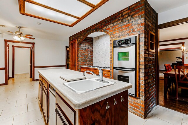 6225 Morton Rd, Katy, TX 77493 - kitchen featuring stainless steel double oven, a sink, a ceiling fan, a kitchen island with sink, and light countertops