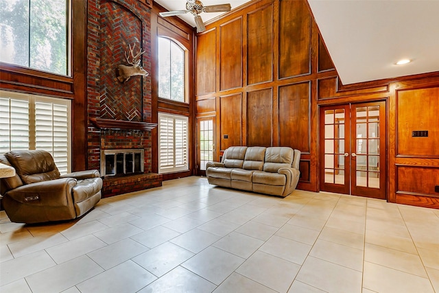 6225 Morton Rd, Katy, TX 77493 - living room featuring a high ceiling, light tile patterned floors, healthy amount of natural light, ceiling fan, and wood walls