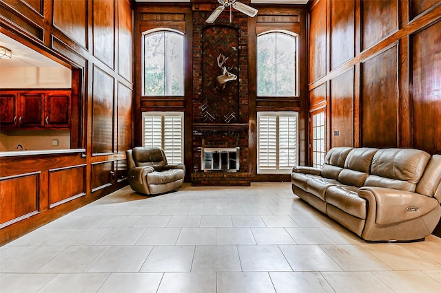 6225 Morton Rd, Katy, TX 77493 - living room featuring a high ceiling, wooden walls, healthy amount of natural light, a ceiling fan, and light tile patterned floors