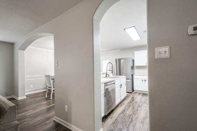 17307 Morning Star Ave, Crosby, TX 77532 - hall with a sink, wood finished floors, arched walkways, baseboards, and a textured wall