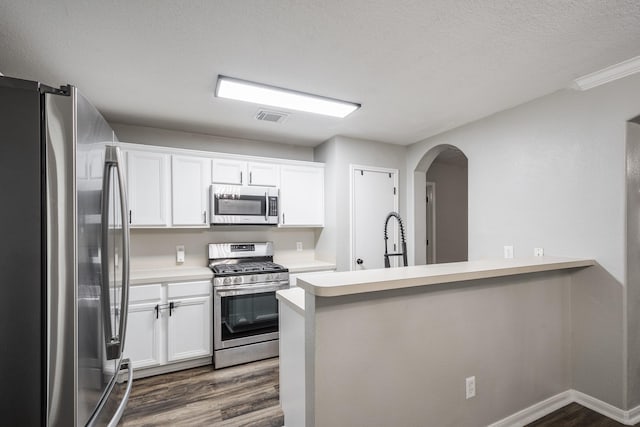 17307 Morning Star Ave, Crosby, TX 77532 - kitchen with stainless steel appliances, dark wood finished floors, arched walkways, and white cabinets
