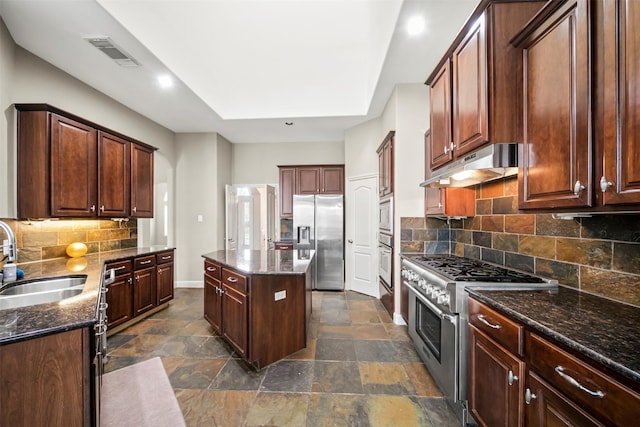 2718 Van Gogh Ln, Missouri City, TX 77459 - kitchen featuring stainless steel appliances, a sink, under cabinet range hood, dark stone counters, and backsplash