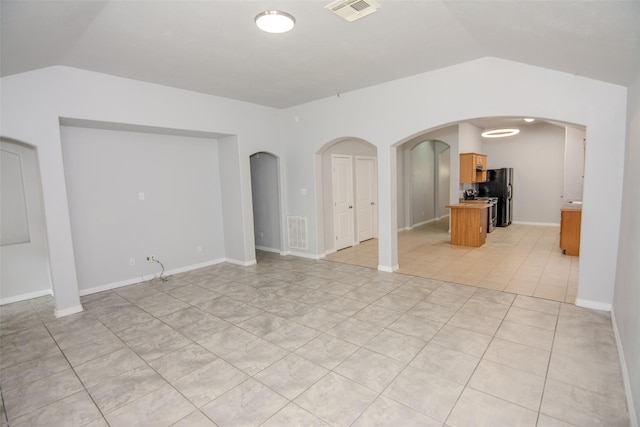 21734 Oriole Trl, Humble, TX 77338 - unfurnished living room featuring lofted ceiling, arched walkways, and light tile patterned floors