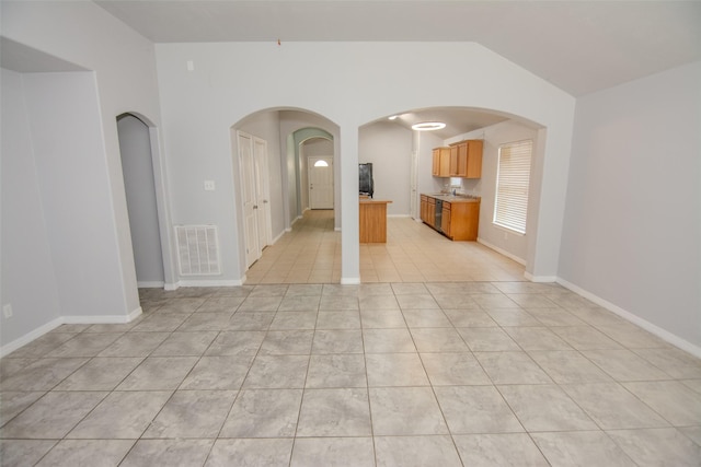 21734 Oriole Trl, Humble, TX 77338 - unfurnished living room featuring vaulted ceiling, arched walkways, baseboards, and light tile patterned floors