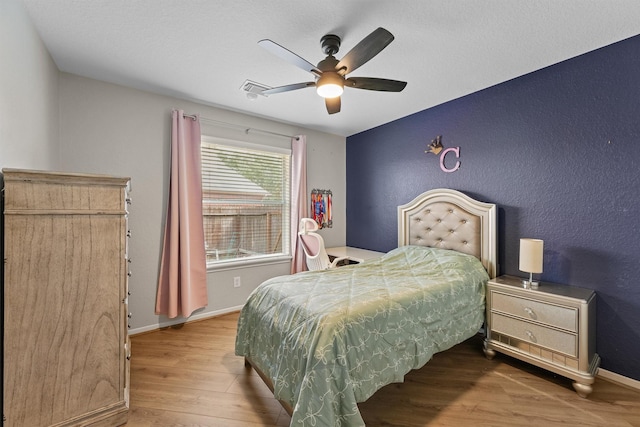 6219 Royal Hollow Ln, Katy, TX 77450 - bedroom with wood finished floors, baseboards, a textured wall, and ceiling fan