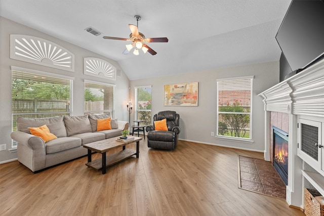 6219 Royal Hollow Ln, Katy, TX 77450 - living area with lofted ceiling, a fireplace, a ceiling fan, light wood-style floors, and baseboards
