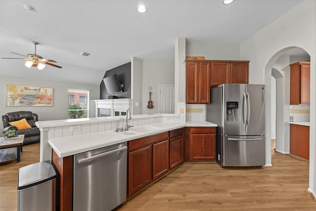 6219 Royal Hollow Ln, Katy, TX 77450 - kitchen with appliances with stainless steel finishes, open floor plan, a peninsula, a sink, and light wood-type flooring