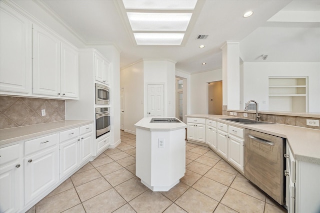 12210 Pebble Mdws, Houston, TX 77041 - kitchen with appliances with stainless steel finishes, a sink, a kitchen island, tasteful backsplash, and white cabinetry