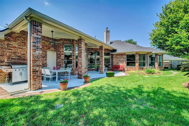 12210 Pebble Mdws, Houston, TX 77041 - back of property with brick siding, a ceiling fan, a chimney, a yard, and a patio