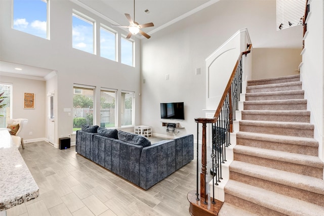 3413 Waverly Springs Ln, Pearland, TX 77581 - living room featuring crown molding, stairs, a towering ceiling, a ceiling fan, and baseboards