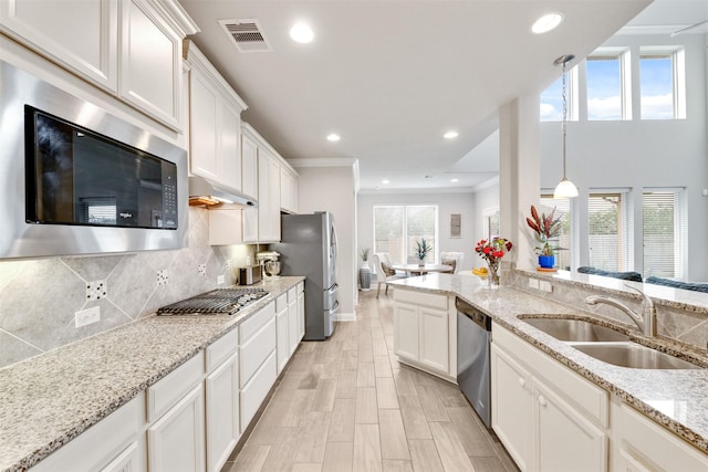 3413 Waverly Springs Ln, Pearland, TX 77581 - kitchen with stainless steel appliances, a sink, crown molding, white cabinetry, and backsplash