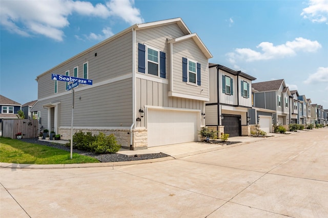 614 Seabreeze Dr, Kemah, TX 77565 - view of front of property with a residential view, a garage, concrete driveway, stone siding, and board and batten siding