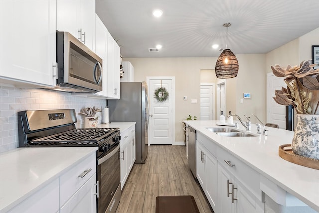 614 Seabreeze Dr, Kemah, TX 77565 - kitchen with appliances with stainless steel finishes, light countertops, white cabinetry, a sink, and recessed lighting