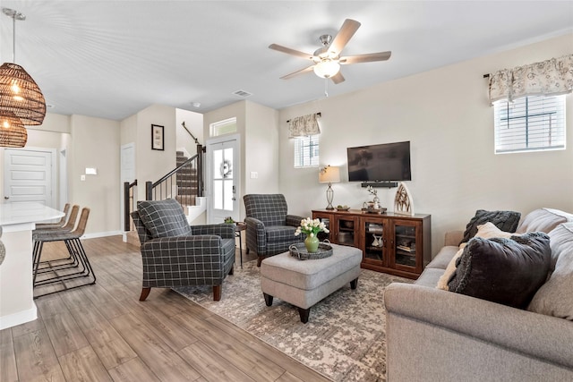 614 Seabreeze Dr, Kemah, TX 77565 - living area with light wood-type flooring, ceiling fan, stairway, and baseboards