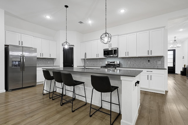 9506 Marble Park Ln, Baytown, TX 77521 - kitchen with stainless steel appliances, dark countertops, a sink, decorative backsplash, and a breakfast bar area