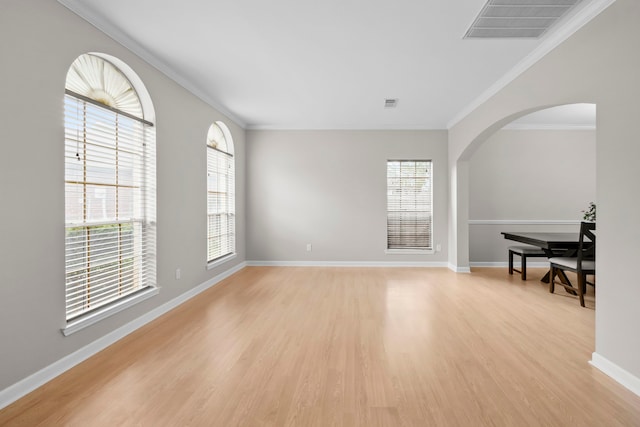 1811 Senca Springs Ct, Katy, TX 77450 - empty room with plenty of natural light, light wood-style floors, ornamental molding, arched walkways, and baseboards