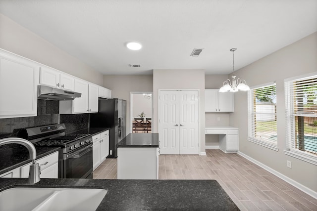 1811 Senca Springs Ct, Katy, TX 77450 - kitchen with under cabinet range hood, stainless steel range with gas cooktop, fridge with ice dispenser, a sink, and backsplash