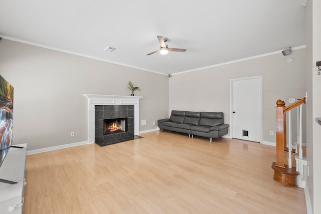 1811 Senca Springs Ct, Katy, TX 77450 - living area featuring ceiling fan, wood finished floors, a fireplace, ornamental molding, and stairs