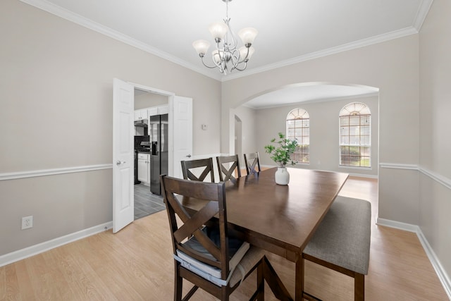 1811 Senca Springs Ct, Katy, TX 77450 - dining room featuring arched walkways, a chandelier, light wood finished floors, baseboards, and ornamental molding