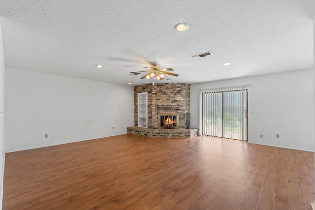 2413 38th Ave N, Texas City, TX 77590 - unfurnished living room with ceiling fan, wood finished floors, a textured ceiling, a fireplace, and recessed lighting