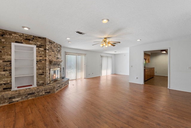 2413 38th Ave N, Texas City, TX 77590 - unfurnished living room featuring wood finished floors, ceiling fan, a fireplace, a textured ceiling, and recessed lighting