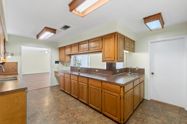 2413 38th Ave N, Texas City, TX 77590 - kitchen with a sink, dark countertops, wall chimney range hood, and baseboards