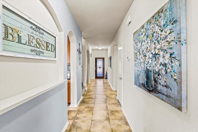 2506 Solitude, Deer Park, TX 77536 - hallway featuring arched walkways, baseboards, and light tile patterned flooring