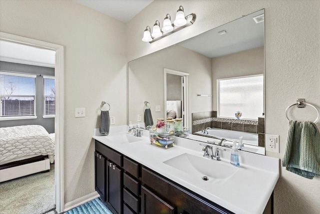 2506 Solitude, Deer Park, TX 77536 - ensuite bathroom featuring double vanity, a garden tub, and a textured wall