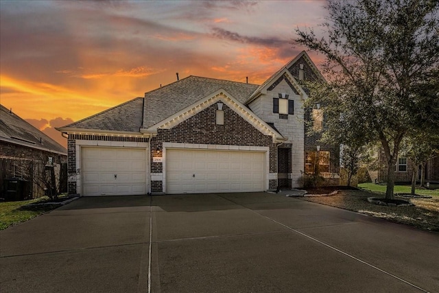 2506 Solitude, Deer Park, TX 77536 - french country home featuring an attached garage, driveway, brick siding, and roof with shingles