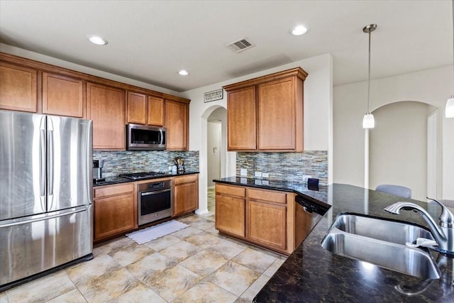 2506 Solitude, Deer Park, TX 77536 - kitchen featuring stainless steel appliances, arched walkways, a sink, tasteful backsplash, and brown cabinets