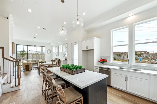 1008 Golden Nectar, Houston, TX 77008 - kitchen with dishwasher, a kitchen island, white cabinets, light stone counters, and light wood finished floors